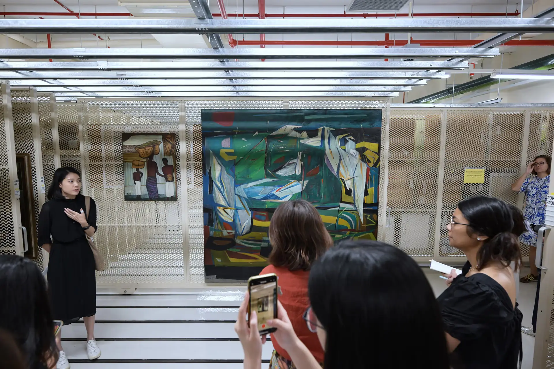Teo Hui Min (left) discussing Chen Wen Hsi’s oil on board work Oasis (1972) during a media tour on Sept 5